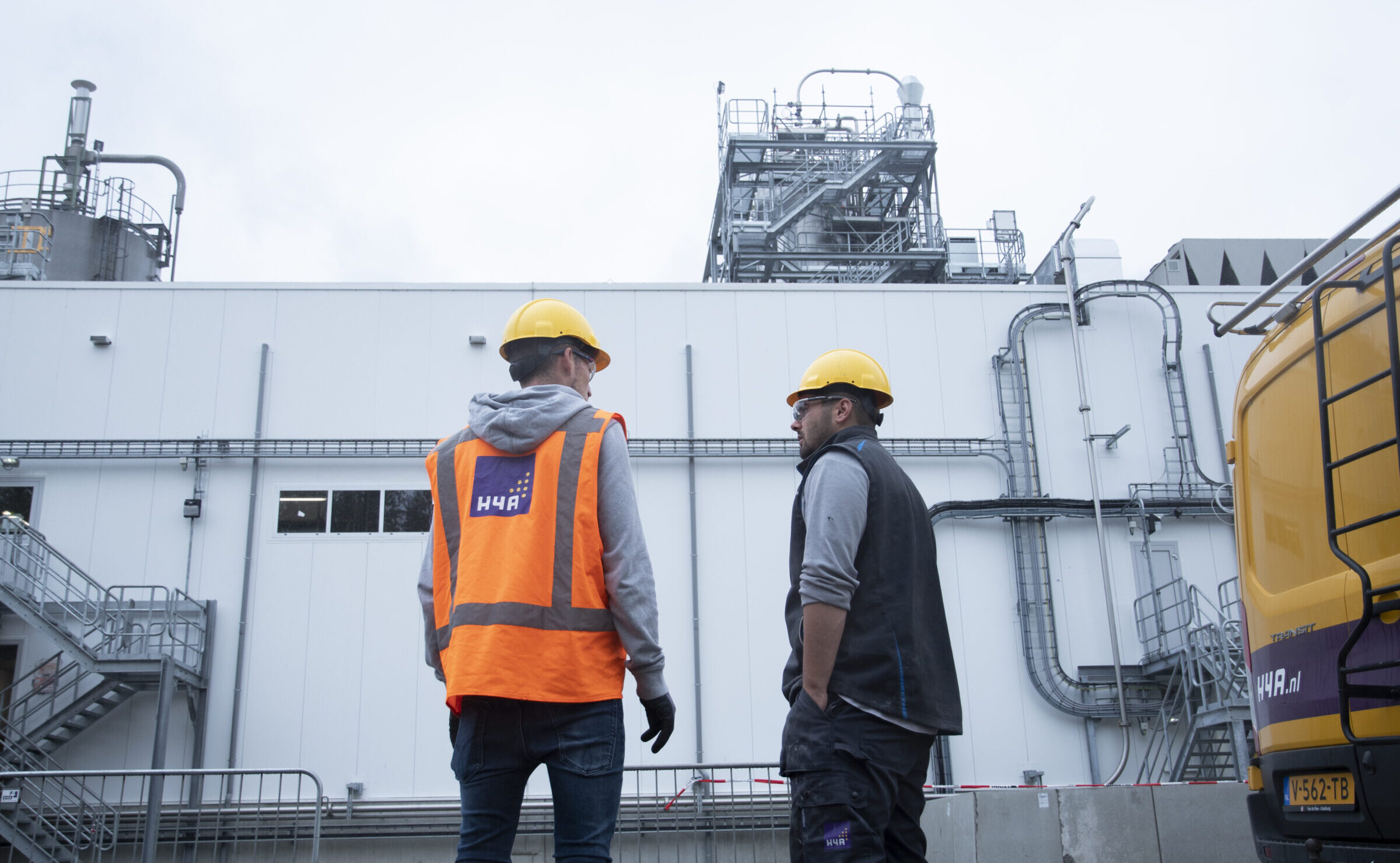 Twee medewerkers van H4A Industrie Service in gesprek bij industriegebouw