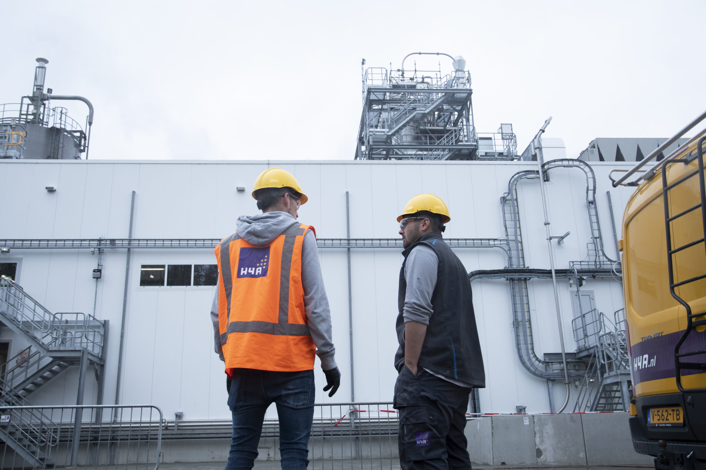 Twee medewerkers van H4A Industrie Service in gesprek bij industriegebouw