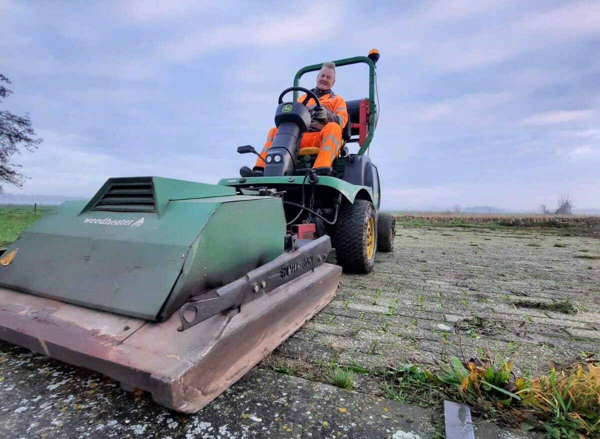 Onkruidbestrijding door medewerker H4A Groen op een machine