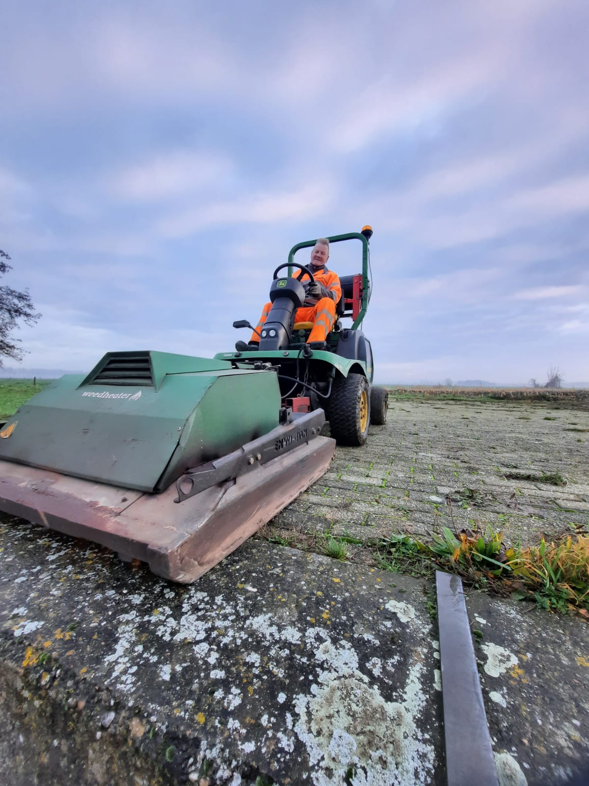 Onkruidbestrijding door medewerker H4A Groen op een machine