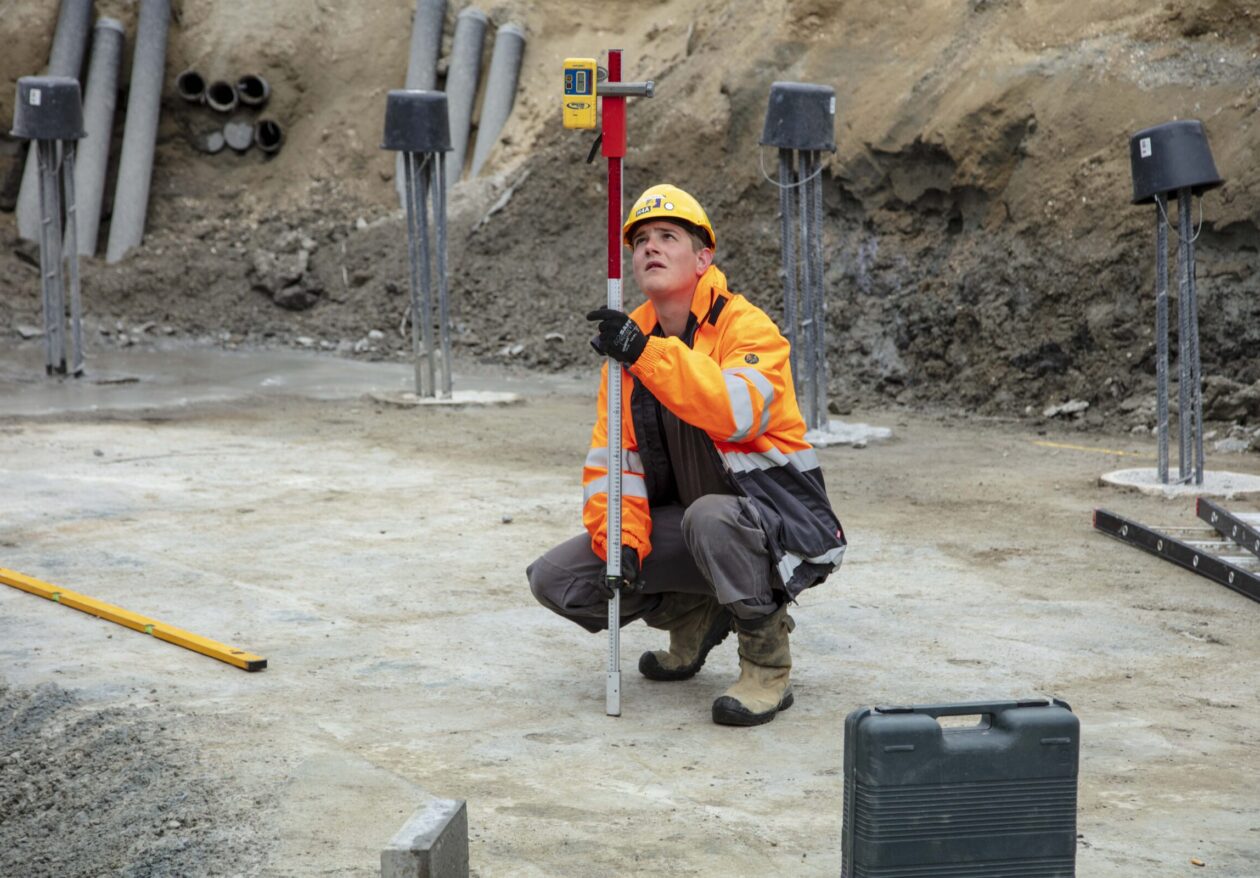 Medewerker H4A Windenergie meet de hoogte bij de fundering voor een windmolen