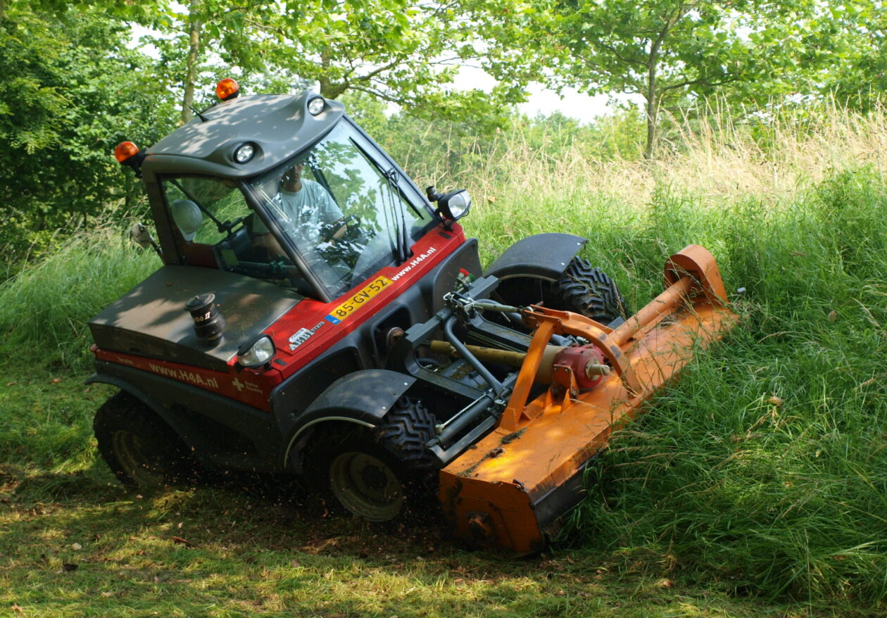 Medewerker H4A Groen in tractor maait het gras