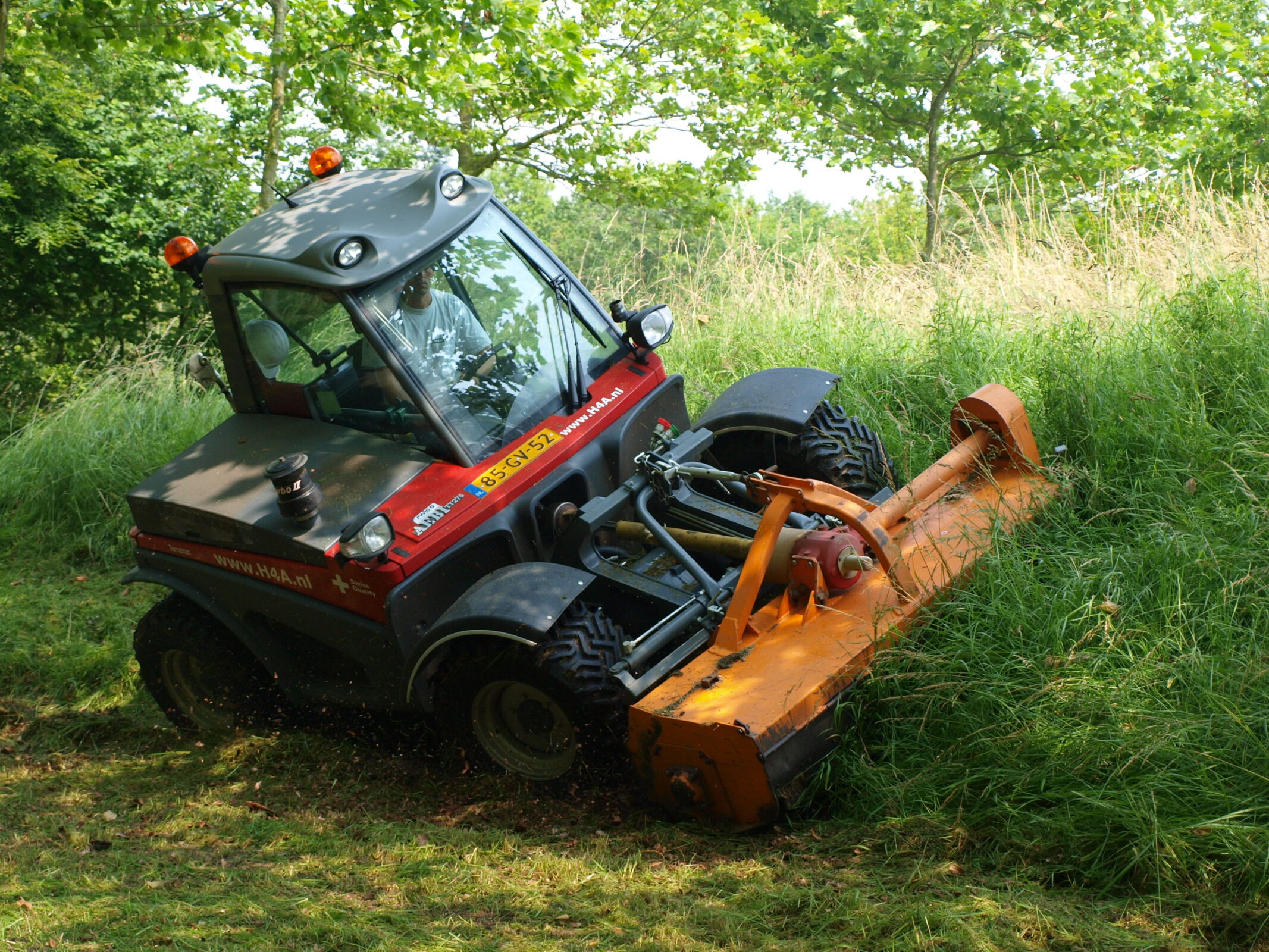 Medewerker H4A Groen in tractor maait het gras