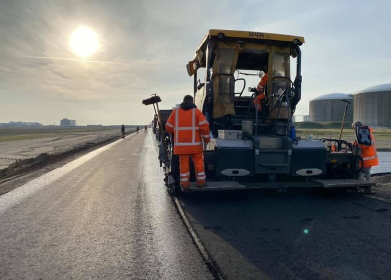 Medewerkers H4A Openbare Ruimte asfalteren een weg