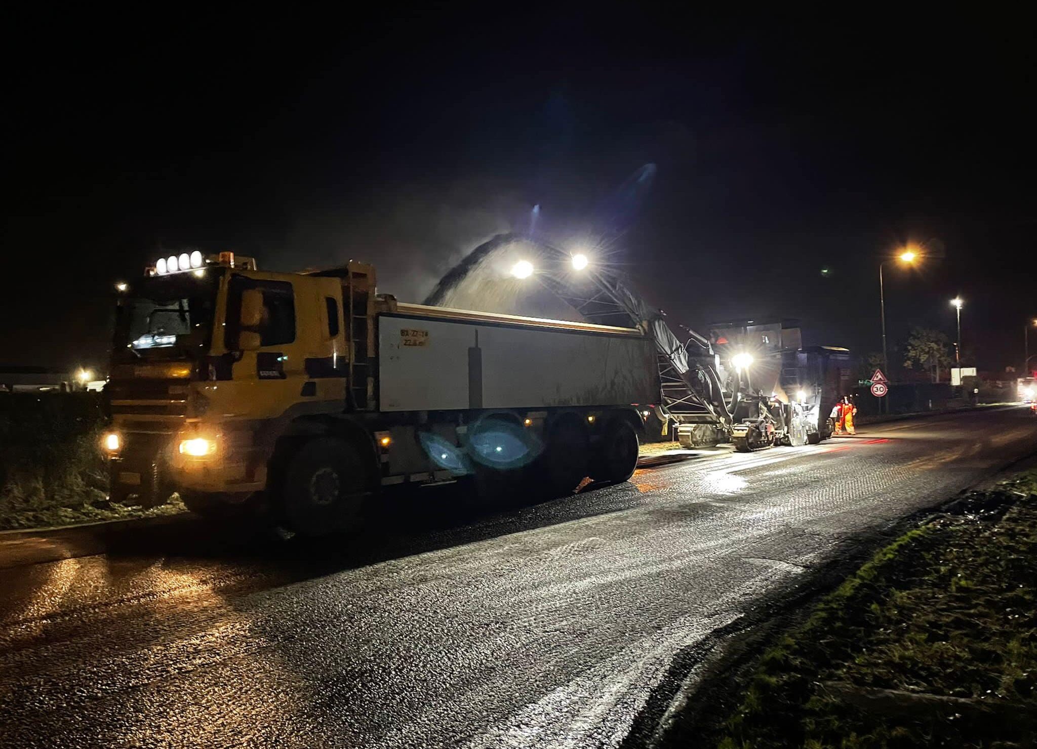 Medewerkers H4A Openbare Ruimte asfalteren 's nachts een weg