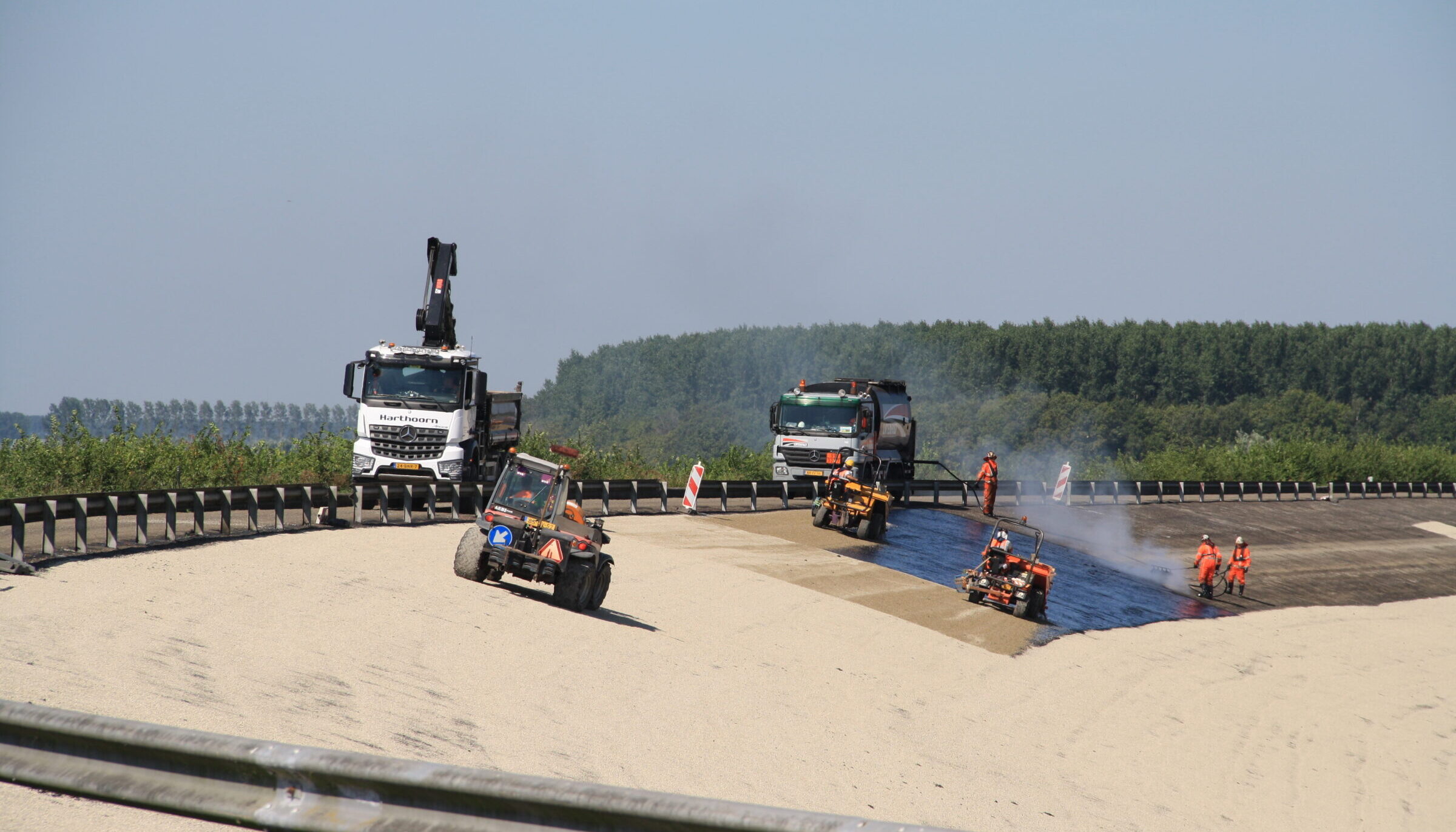 Medewerkers H4A Openbare Ruimte voeren oppervlakbehandeling uit aan talud