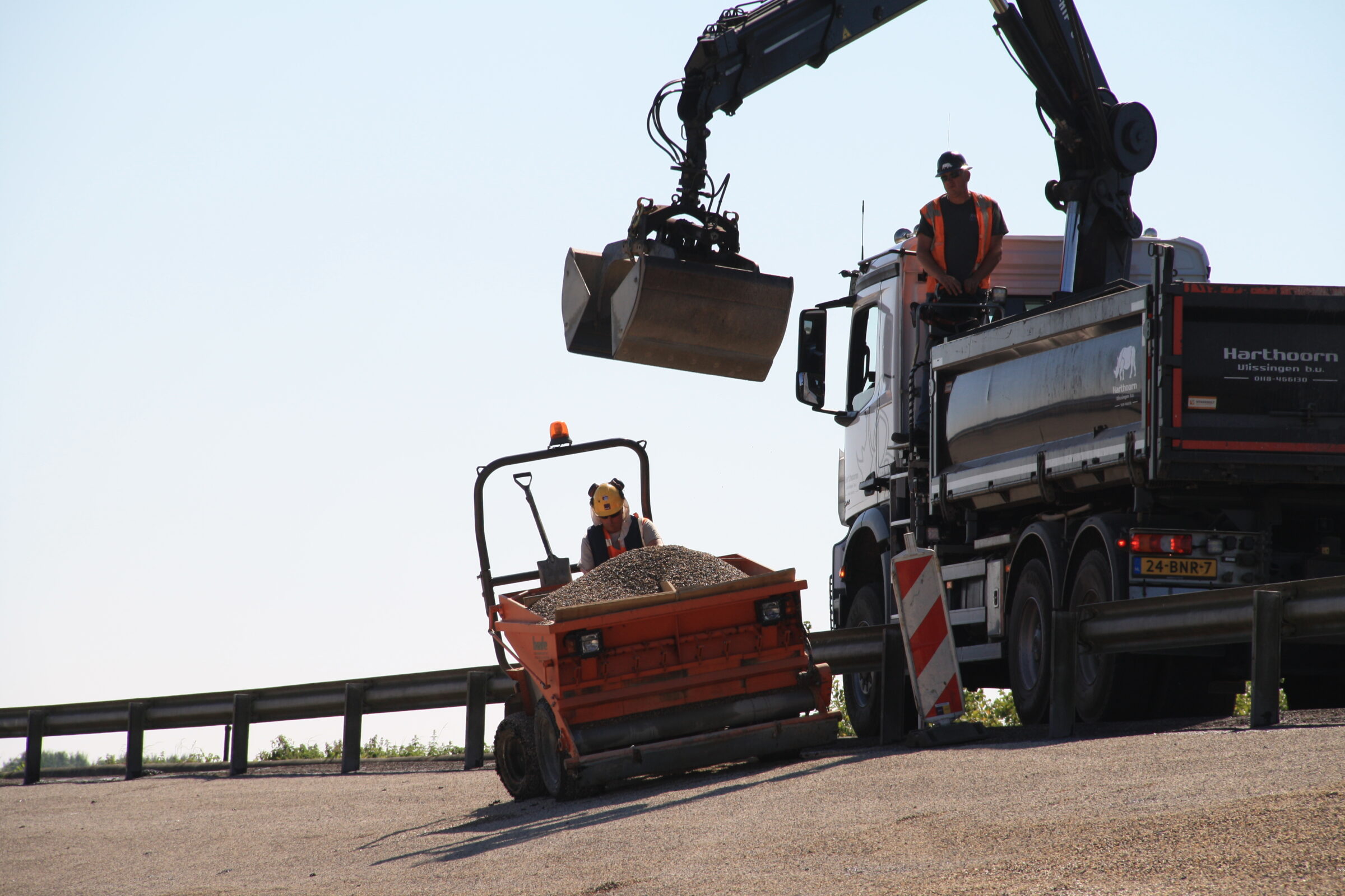 Medewerkers H4A Openbare Ruimte voeren oppervlakbehandeling uit aan talud