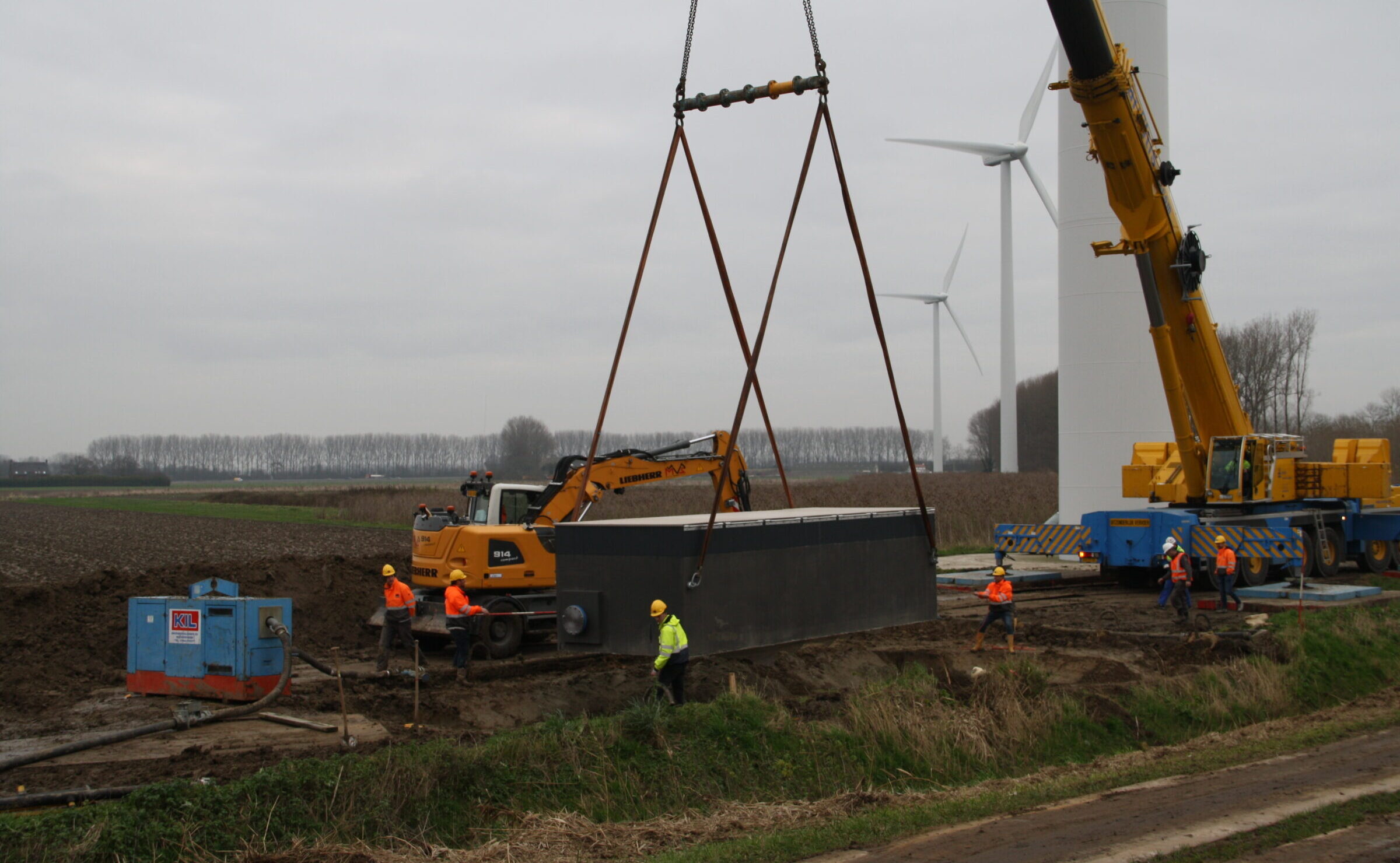 Plaatsing van een grote watermeterput door medewerkers H4A Ondergrondse Netwerken