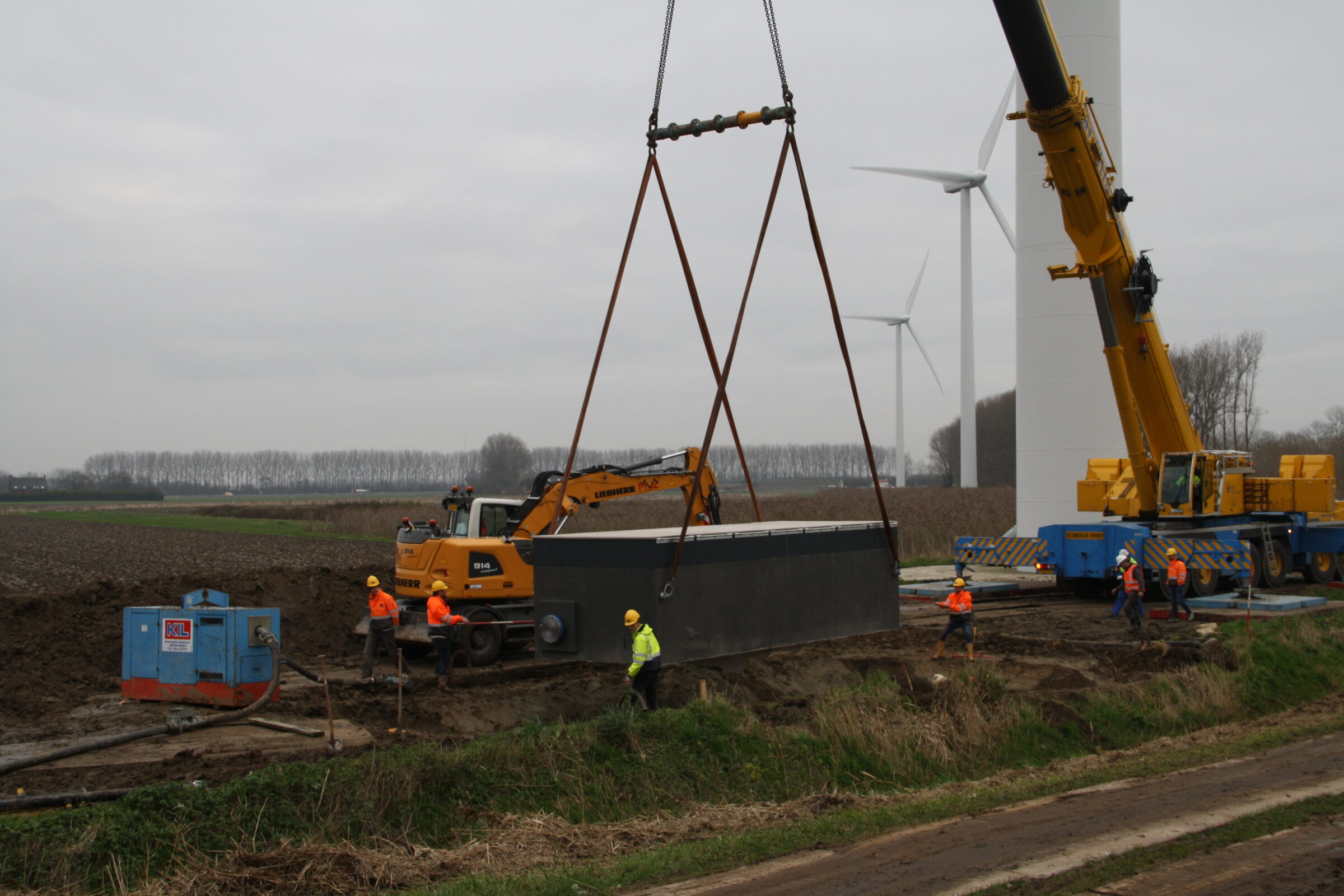 Plaatsing van een grote watermeterput door medewerkers H4A Ondergrondse Netwerken