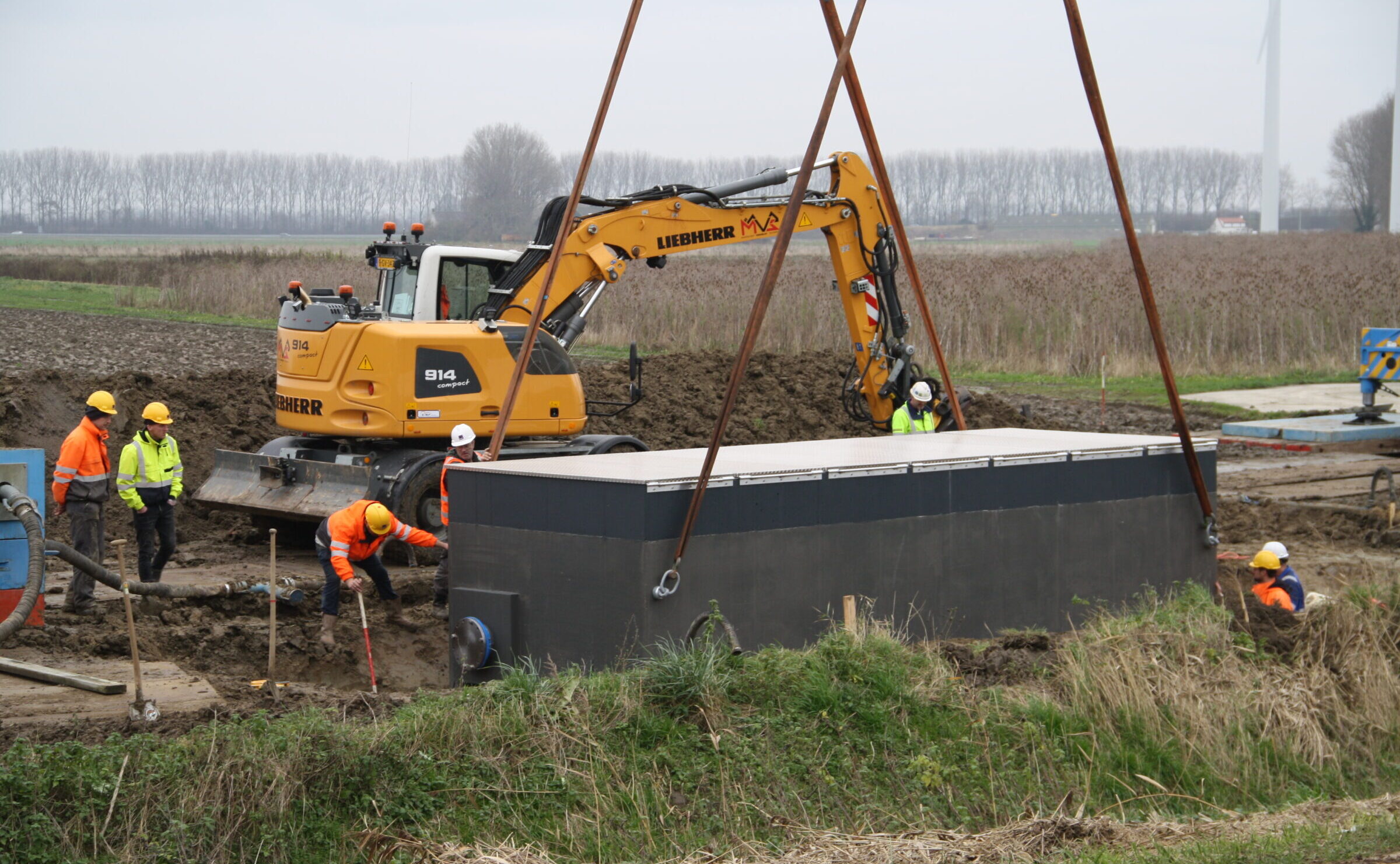 Plaatsing van een grote watermeterput door medewerkers H4A Ondergrondse Netwerken