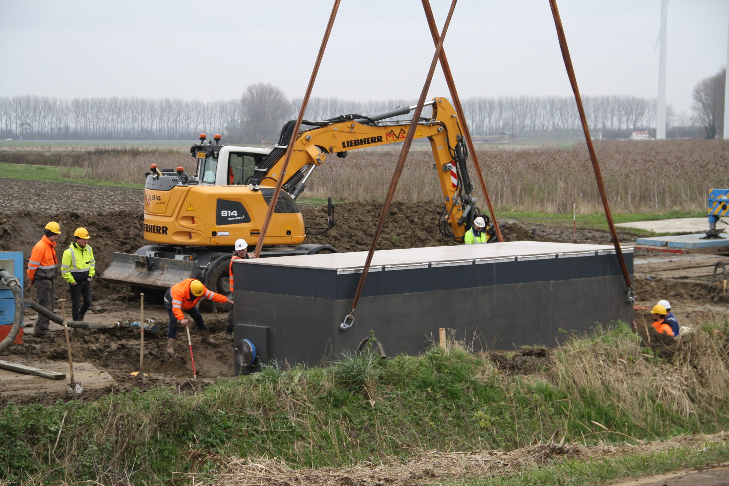 Plaatsing van een grote watermeterput door medewerkers H4A Ondergrondse Netwerken