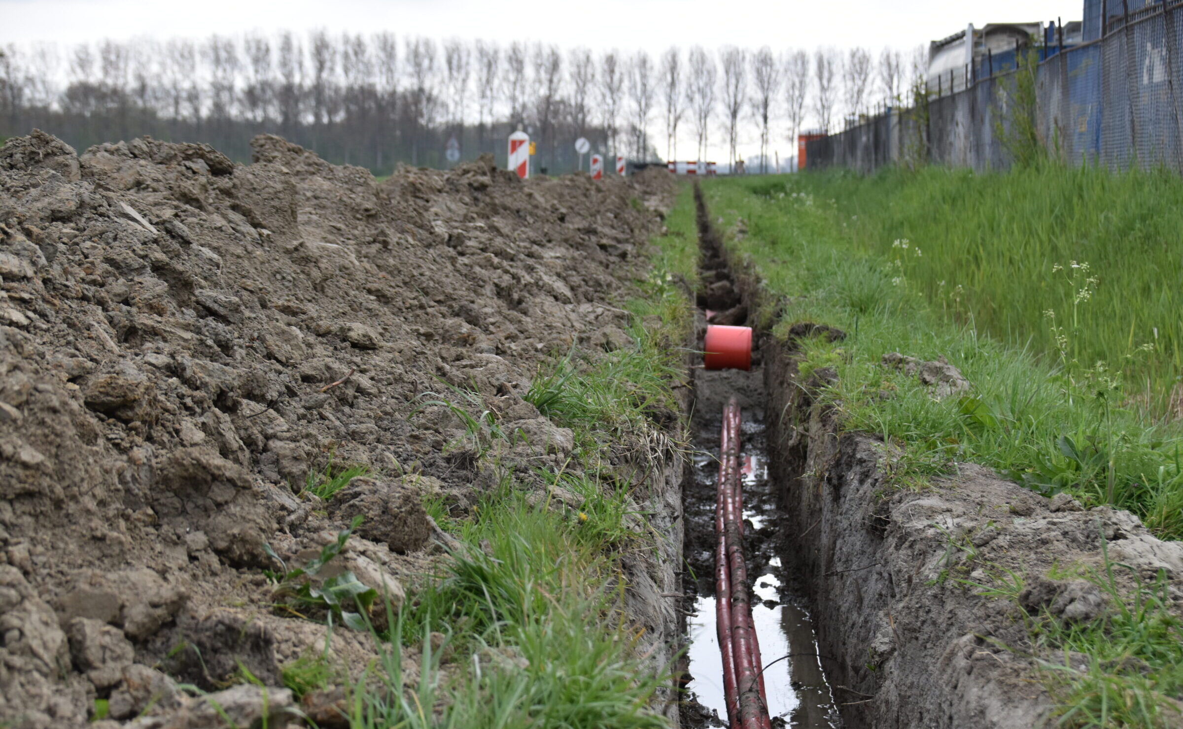 Medewerker van H4A Ondergrondse Netwerken aan het werk voor de aanleg van een zonnepark in Sas van Gent